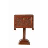A writting cabinet on a single foot, Lusíada, carved teak decorated with foliate scrolls,