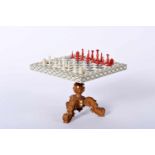 A miniature Game Table with miniature Chess Pieces, table with carved walnut foot with ivory