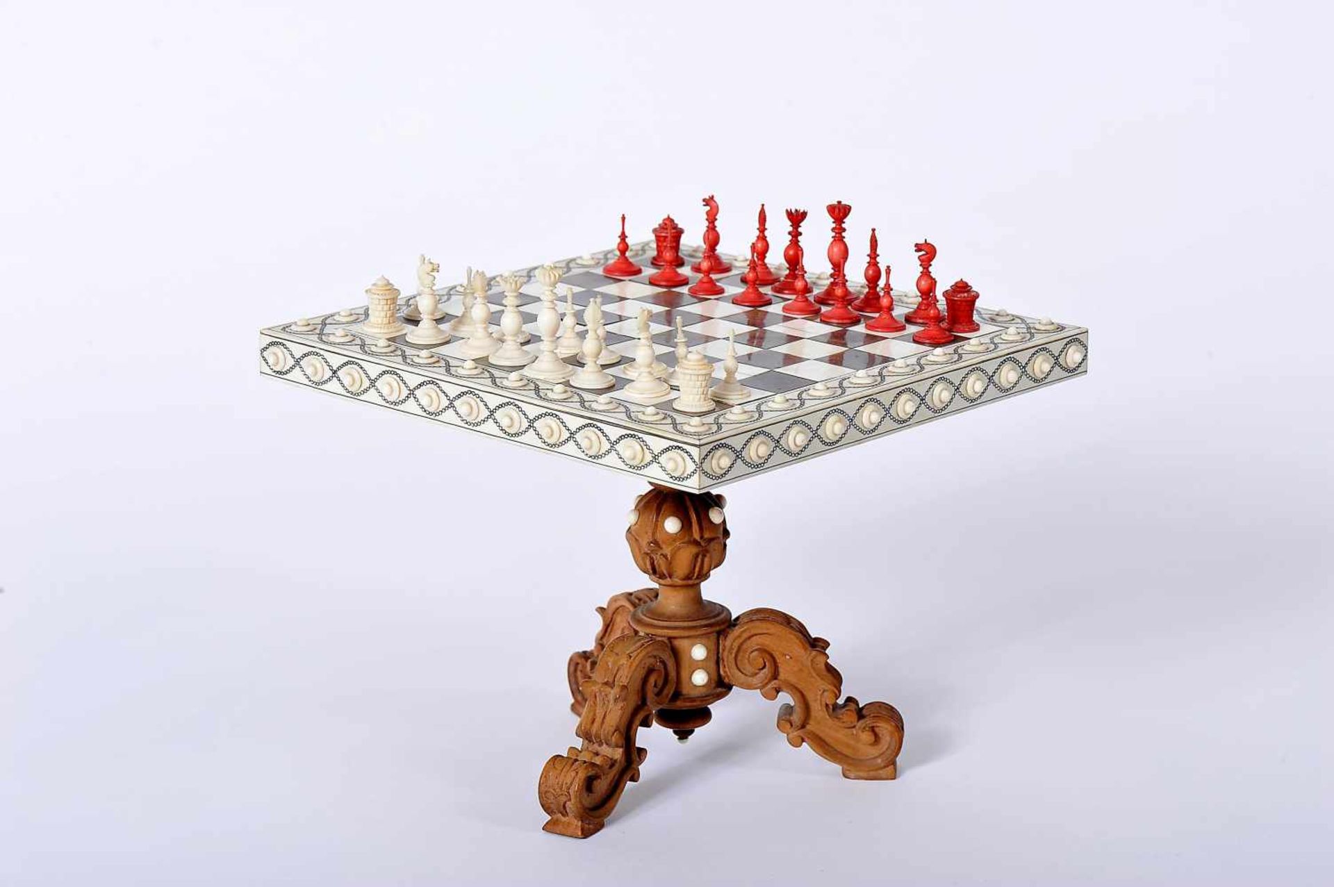 A miniature Game Table with miniature Chess Pieces, table with carved walnut foot with ivory