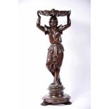 A Column, carved and darkened walnut "Lady holding shell on her head", darkened chestnut round