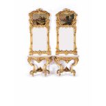 A Pair of Pier Glasses with Credences, Louis XV style, carvd and gilt wood ""Volutes and shell