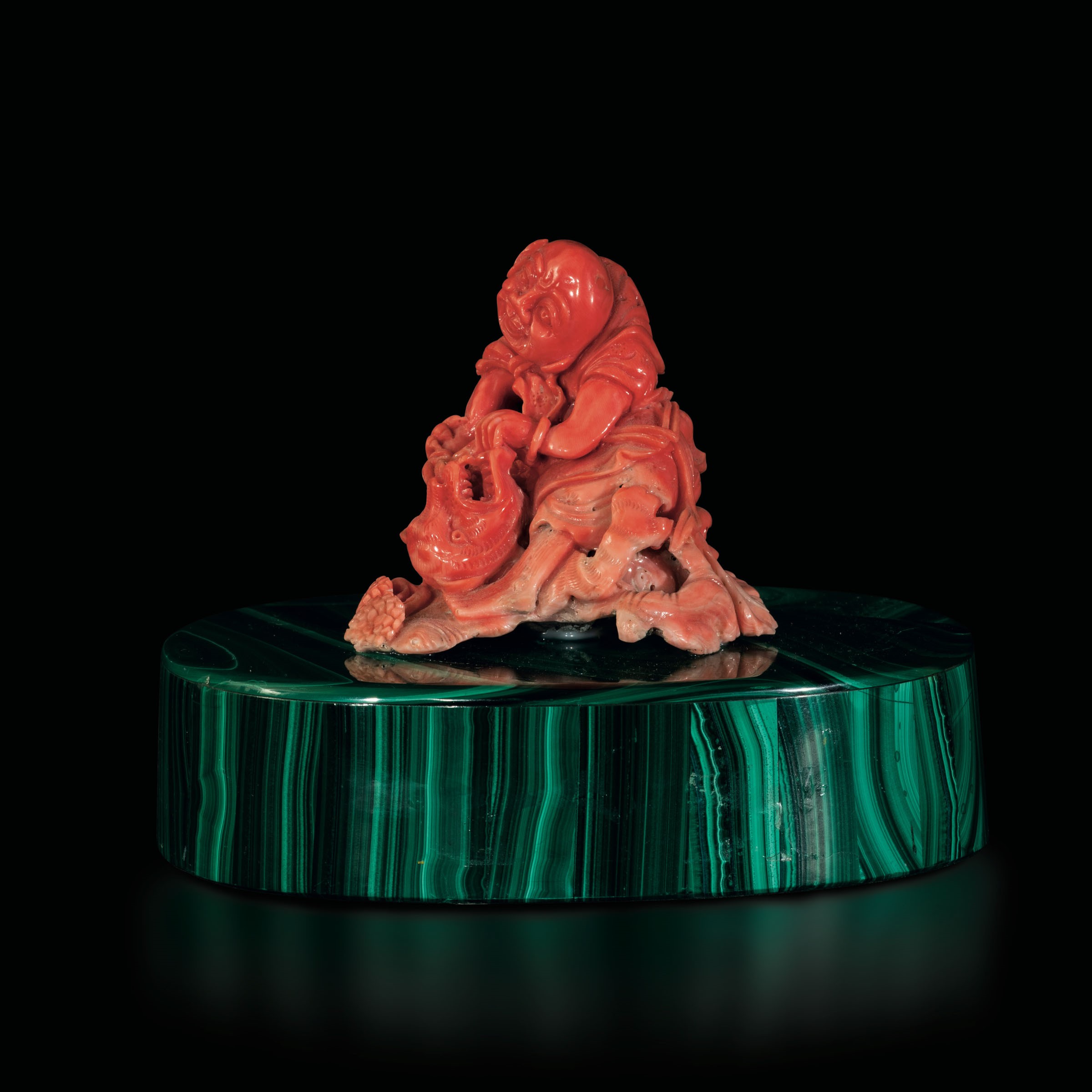 A carved coral group on a malachite base, China, early 1900s - Gross weight 1350gr; H [...]