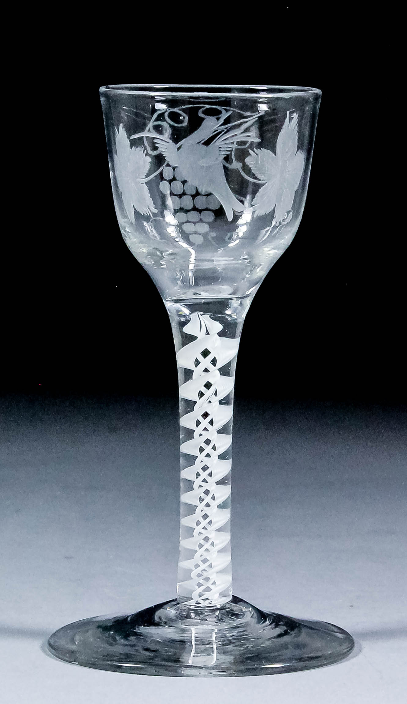 An 18th Century air twist wine glass, the bucket bowl engraved with a bird and fruiting vine, on a