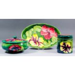 Three pieces of Moorcroft pottery, tube lined and decorated in colours with "Orchids" design on a