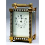 A late 19th/early 20th Century French gilt brass cased carriage timepiece, the cream enamel dial