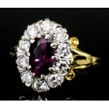 A modern 18ct gold mounted ruby and diamond oval cluster ring, set with central oval ruby (