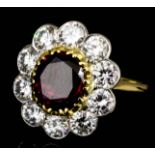 A modern 18ct gold mounted ruby and diamond oval cluster ring, set with central oval ruby (