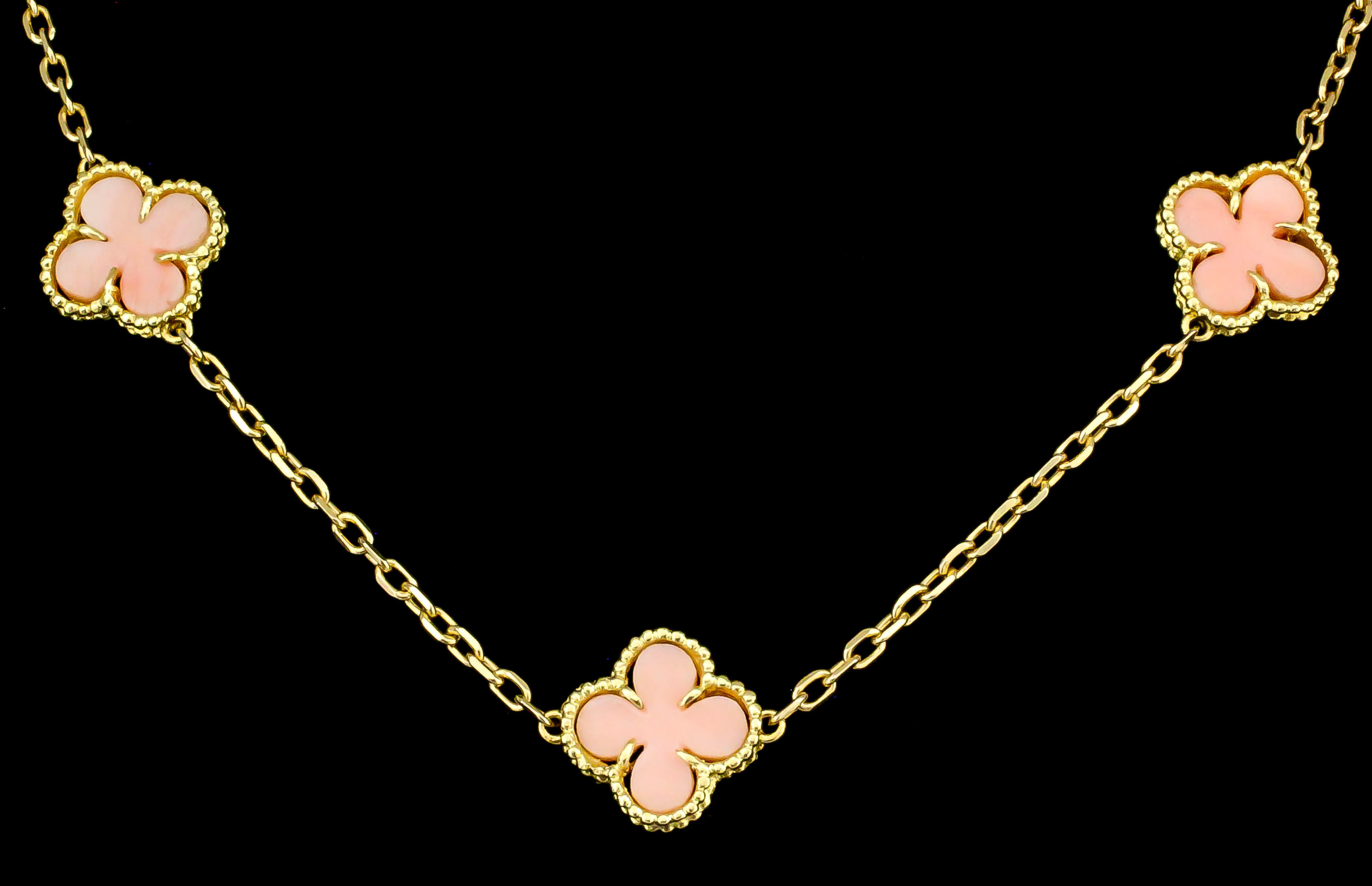 A 20th Century 18ct gold mounted coral necklace, comprising fifteen "clover leaf" coral motifs,