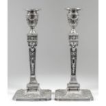 A pair of George V silver pillar candlesticks of Neo-Classical form with bead mounts to sconces