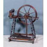 An 18th Century walnut spinning wheel with slender turned spindles, 24.5ins high overall (with