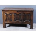 A 17th/18th Century panelled oak coffer with plain lid and three shaped and moulded panels to front,