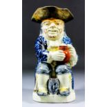 An early 19th Century Staffordshire pottery "bearded" Toby jug of Wood type, with pipe, barrel and
