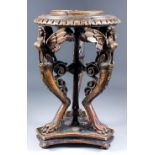 A late 19th/early 20th Century carved wood circular stand supported by three sphinx atop monopodia