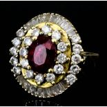 A modern gold coloured metal mounted ruby and diamond cluster ring, set with central ruby (