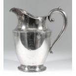 A 20th Century American "Sterling" silver water jug with urn pattern body and scroll handle, on