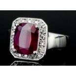 A modern 14ct white gold mounted ruby and diamond ring, the central ruby (approximately 4ct)