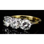 A modern gold coloured metal mounted three stone diamond ring, set with three round brilliant cut