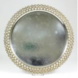 An Elizabeth II silver and silver gilt circular tray with hammered finish to the centre, with a cast