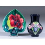 A Moorcroft pottery vase, tube lined and decorated in colours with "Orchid" design on a blue ground,