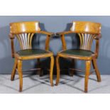 A pair of early 20th Century oak library armchairs with plain curved crest rails, fretted splats,