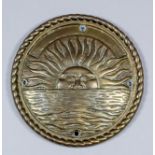 A circular brass P. & O. Lifeboat badge cast with a rising sun over the sea, within rope pattern