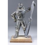 A silver plated table lighter in the form of Charles Kingsford Smith holding a propeller, 9.75ins