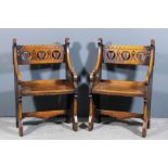 A pair of Victorian oak armchairs of ecclesiastical Gothic design, the backs fretted and carved with