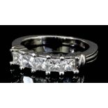 A modern platinum mounted five stone diamond ring, with emerald cut diamonds in raised channel, (