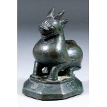 A Thai brown patinated bronze weight modelled as a squatting mythological creature, on octagonal