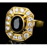 A modern gold coloured metal mounted sapphire and diamond ring set with central oval sapphire (