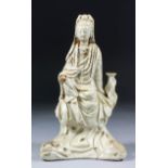 A Chinese Blanc-de-chine porcelain figure of Guanyin, 8.25ins (21cm) high (both acolytes missing)