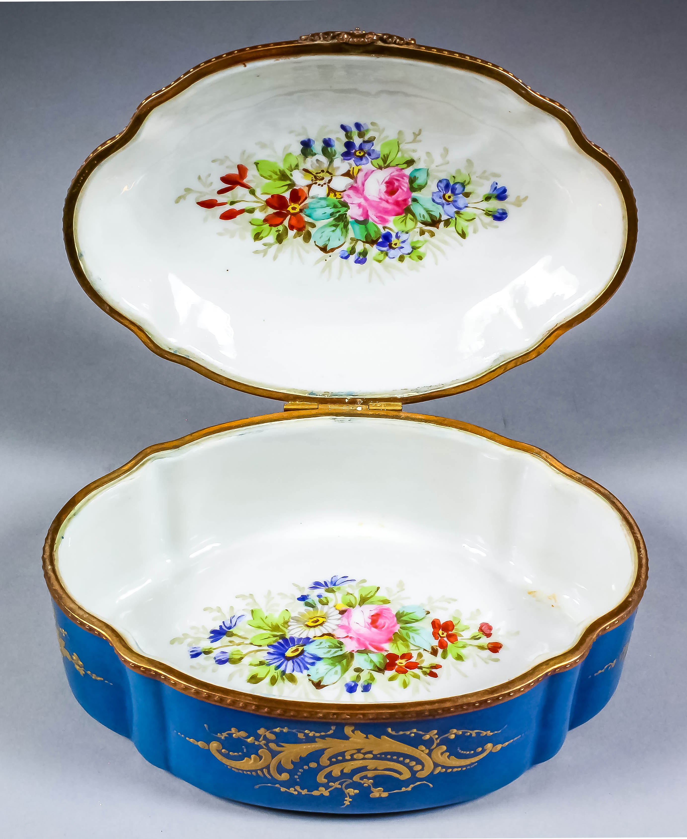 A late 19th Century Continental porcelain box and cover of shaped outline with gilt metal mounts,