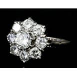 An 18ct white gold mounted "flowerhead" diamond ring, set with a brilliant cut central diamond (