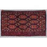 An antique Tekke Turkmen Juval woven in navy blue, rose and ivory with three rows, each of three