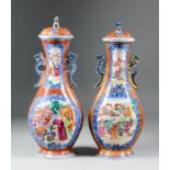 A pair of Chinese "Cantonese" porcelain two-handled vases and covers, the moulded bodies enamelled