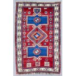 A Kazak rug woven in colours with central lozenge shaped medallion and two rectangular medallions