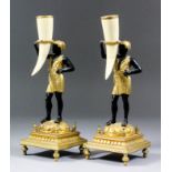 A pair of 19th Century French gilt brass and bronzed finish pillar candlesticks modelled as a