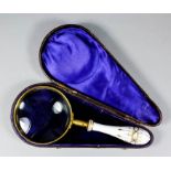 A late 19th Century engine turned gilt brass mounted magnifying glass with gilt and white