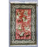 An Isfahan picture rug woven in muted colours with a hunting scene with six huntsmen on horseback,