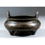 A Chinese dark patinated bronze circular two-handled censer of squat form, 5ins (12.7cm) diameter