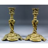 A pair of late 19th Century gilt brass candlesticks and drip pans of "Baroque" design, 10.25ins