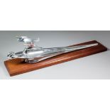 An American chrome car mascot in the form of an airship, on a wooden plinth, 22ins long