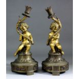 A pair of late 19th Century French partial gilt bronze table lamps modelled as cherubs supporting an