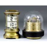 A Continental lacquered brass and glass cylindrical desk timepiece with two revolving drums of