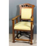 An early 20th Century oak open armchair of "Arts and Crafts" design, the shaped crest rail fretted