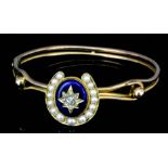 A gold coloured metal mounted diamond blue enamel and seed pearl stiff bangle, the horseshoe