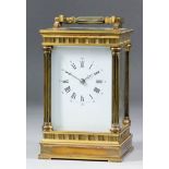 An early 20th Century carriage clock, the white enamel dial with Roman and Arabic numerals, to the