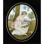A late Georgian silk needlework panel depicting a classical maiden making a floral garland, oval 9.