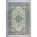 A Kashan carpet woven in muted shades with bold central medallion and conforming spandrels, the