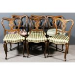 A set of six Victorian rosewood dining chairs with shaped crest rails, fretted and scroll carved